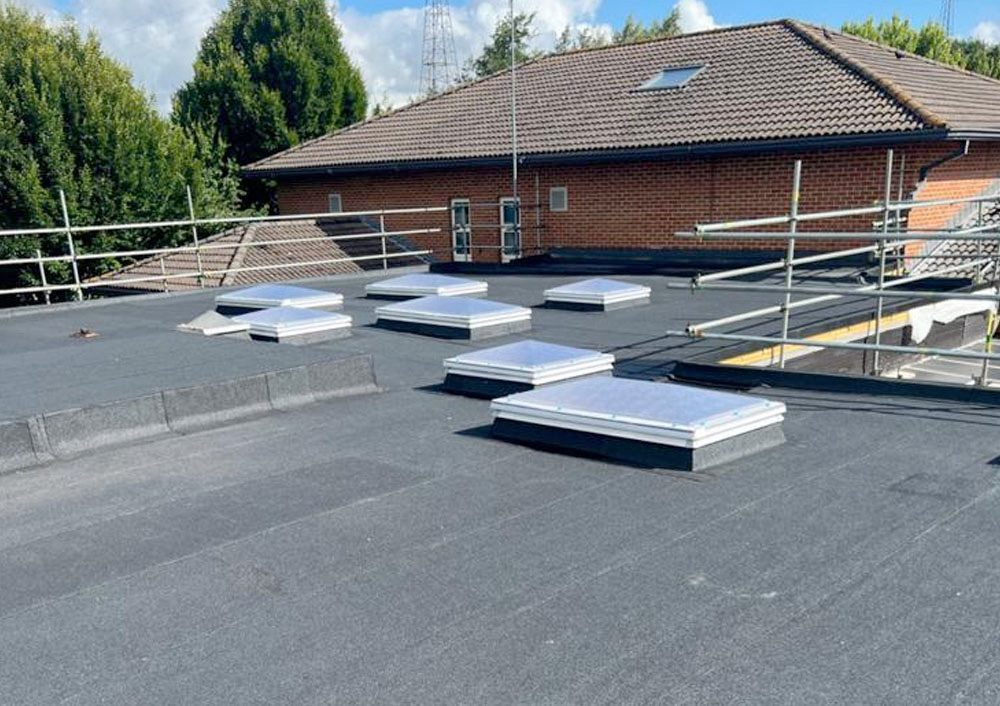 Refurbished built-up roof with new rooflights beside a campus building, Coventry University